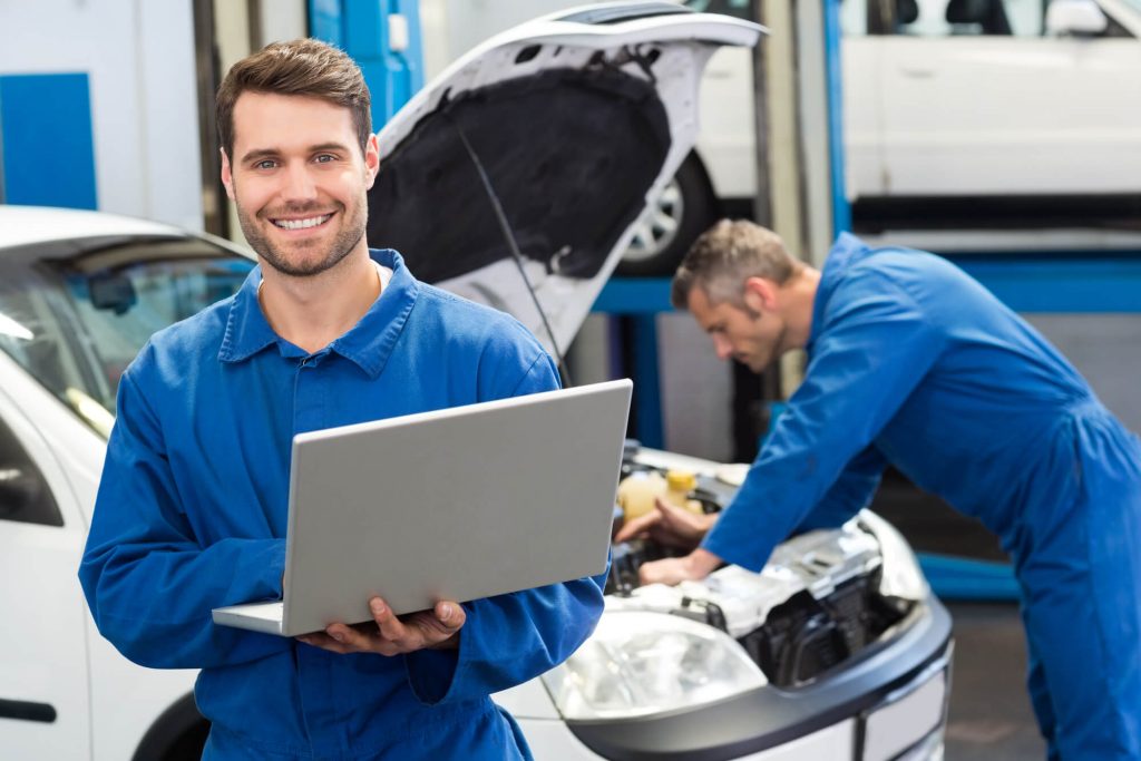 An expert in Mercedes Repair in Davie FL holding a laptop