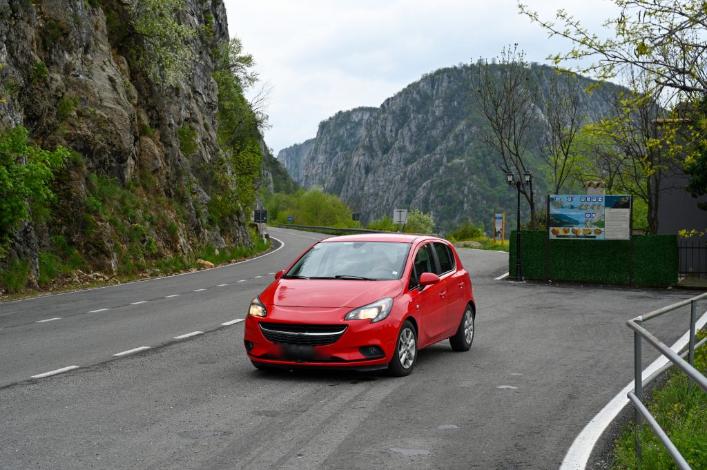 red car on the road in the mountains in the Djerdap gorge in Serbia.